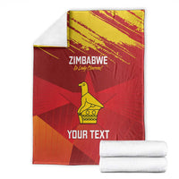 Zimbabwe cricket blanket folded with stacked white towels, red with yellow emblem and “YOUR TEXT”