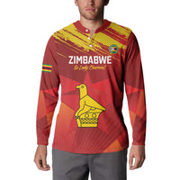 Red cricket button sweatshirt on model, Zimbabwe logo and yellow bird graphic, long sleeves