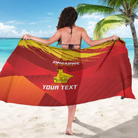 Red sarong held open, showing yellow Zimbabwe crest, grunge chevron stripes, and custom text