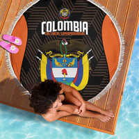 Round black beach blanket with white fringe, orange edge, and Colombia crest design