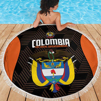 Round black Colombia beach blanket with white fringe, crest and logo text in center