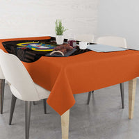 Orange football tablecloth with draped edges and black emblem print on table