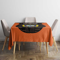 Orange football tablecloth with black crest graphic centered on table