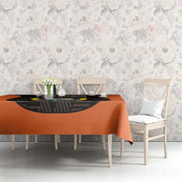 Orange football tablecloth with black printed crest and draped corners on table