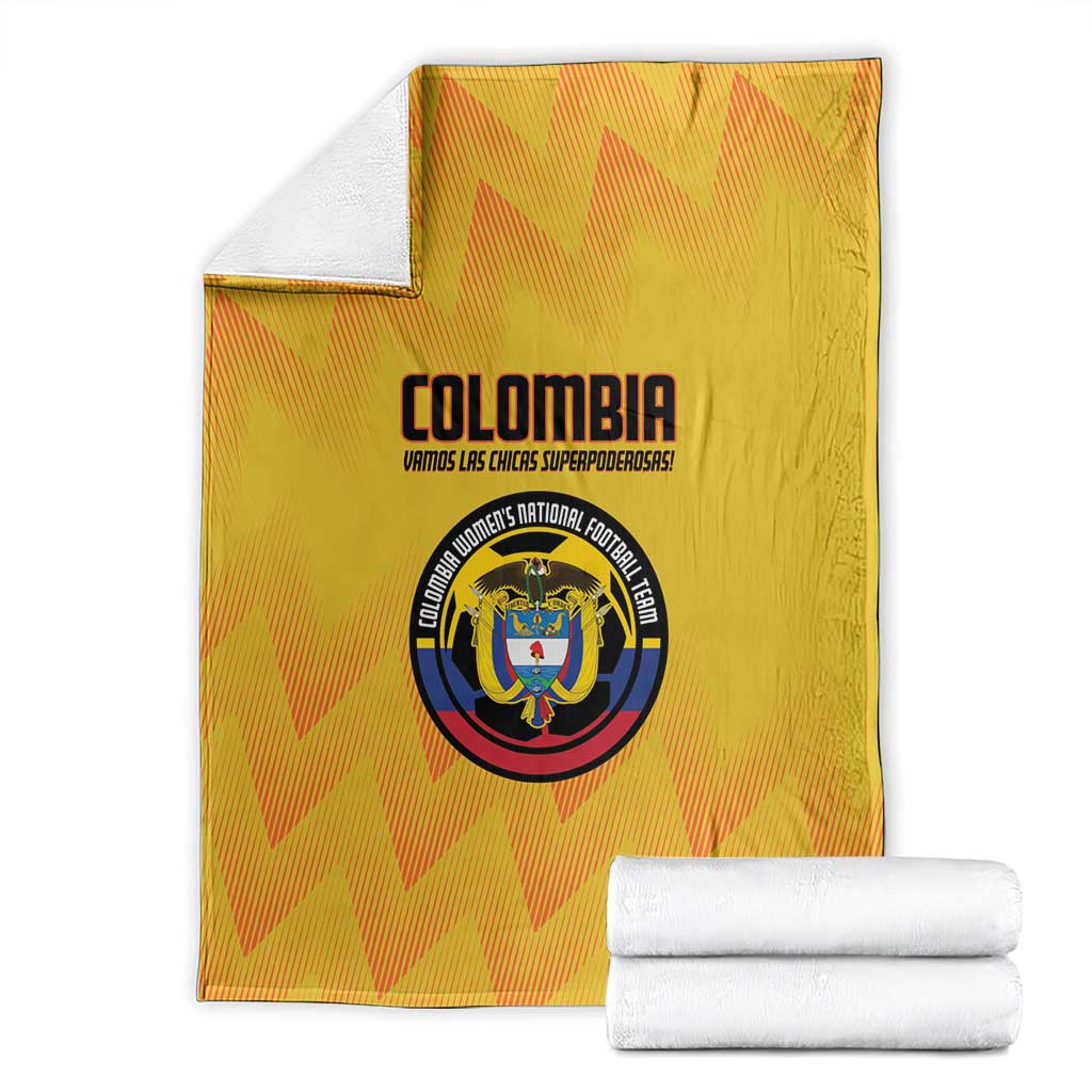 Yellow Colombia football blanket with crest emblem, shown beside rolled white towels