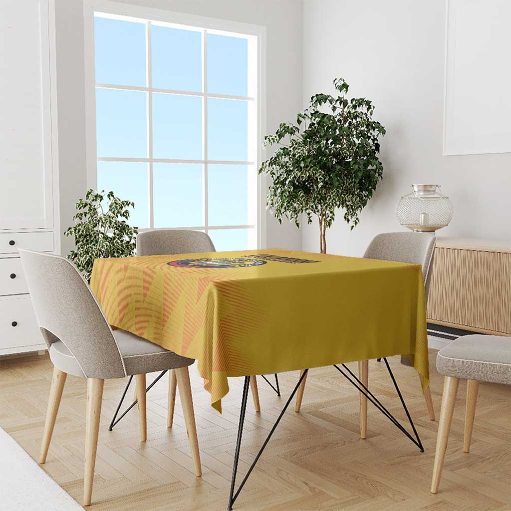 Yellow football tablecloth with printed crest on top, draped over rectangular dining table.