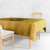 Yellow football tablecloth with graphic circular crest in the center, draped over table.