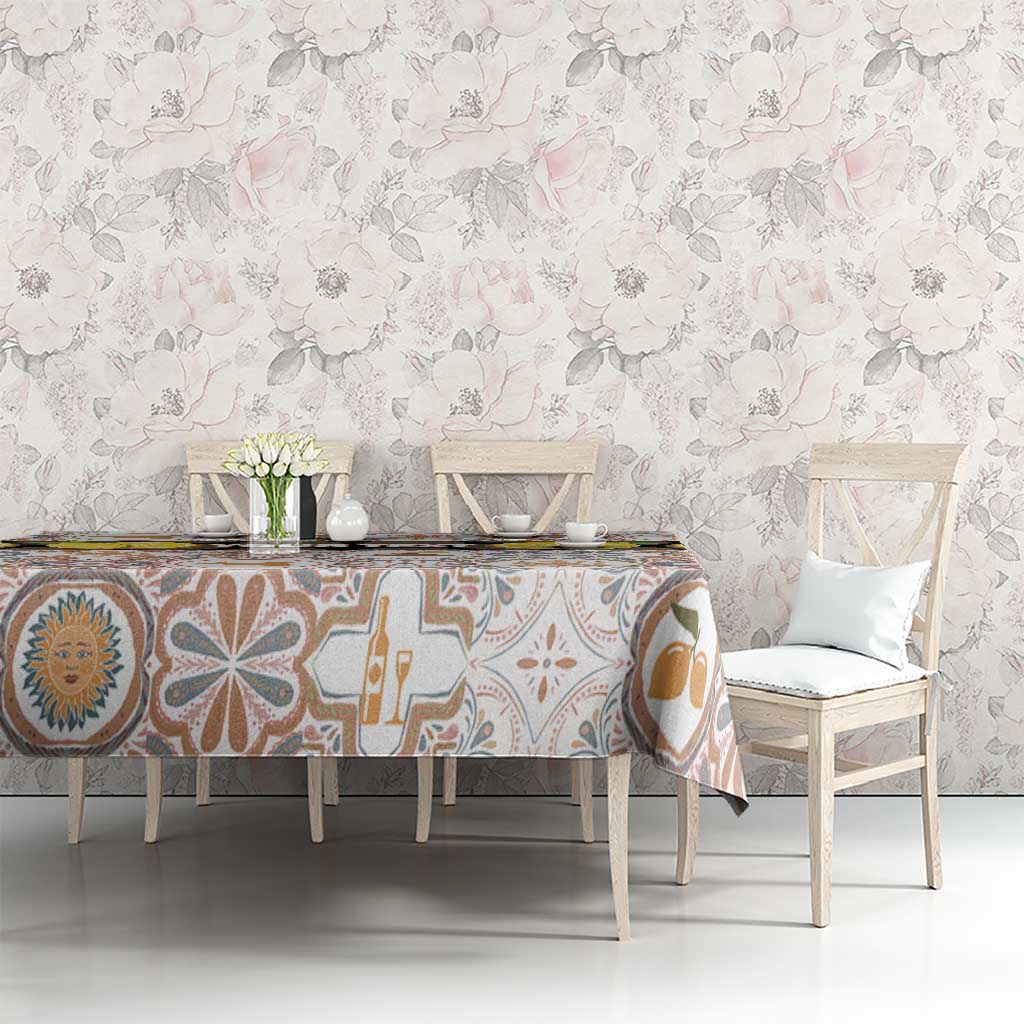 Dining table with tablecloth featuring Sicilian mosaic motifs in blue, tan, and yellow on cream