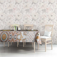 Dining table with tablecloth featuring Sicilian mosaic motifs in blue, tan, and yellow on cream