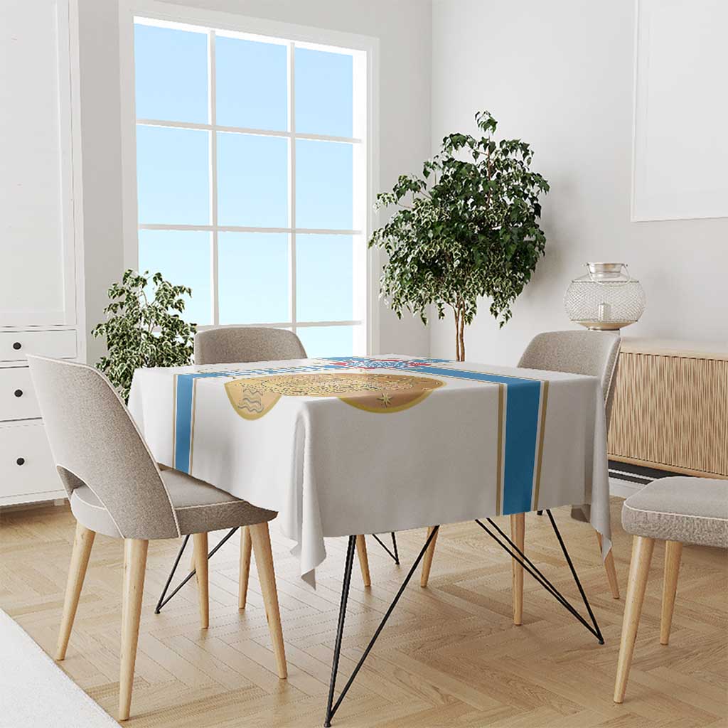 White tablecloth with blue side stripe and gold emblem on dining table
