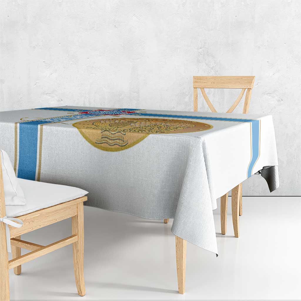 White tablecloth draped over table with blue trim and gold emblem center