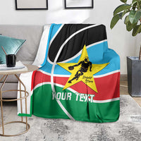 Custom basketball blanket on floor beside table, black/blue/green/red with yellow star and 'Your Text'