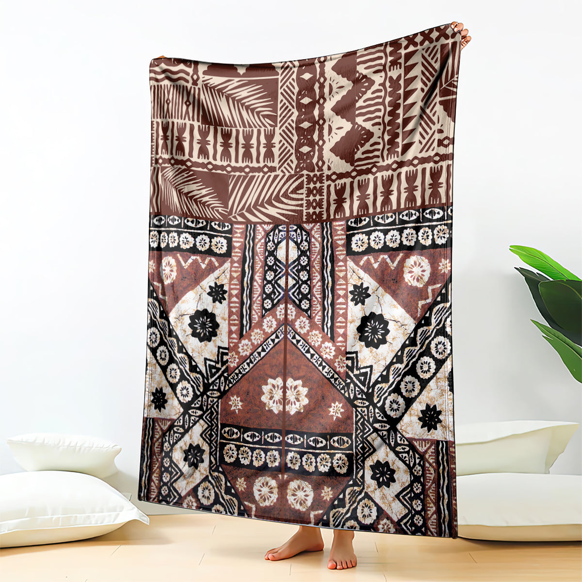 Brown geometric tapa-pattern blanket with black accents and white motifs, draped