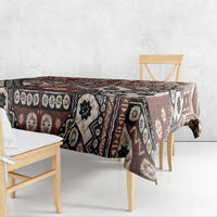 Brown tapa-style tablecloth with black and cream geometric medallion pattern.