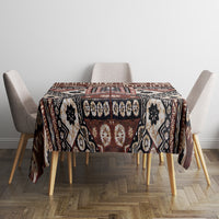 Brown tapa-inspired tablecloth featuring black, cream, and rust panel motifs.