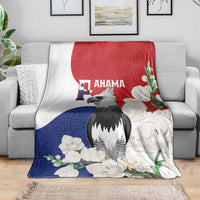 Flag-style throw blanket with harpy eagle, red blue white floral mola pattern, folded on couch