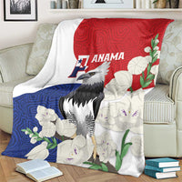 Flag-style throw blanket with harpy eagle, red blue white floral mola pattern, on armchair