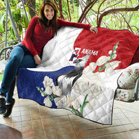 Quilt blanket draped over sofa, white with red and blue sections; harpy eagle and blossoms