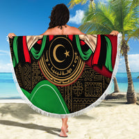Round Libya beach blanket with white fringe, large “LIBYA” emblem, flag colors on display