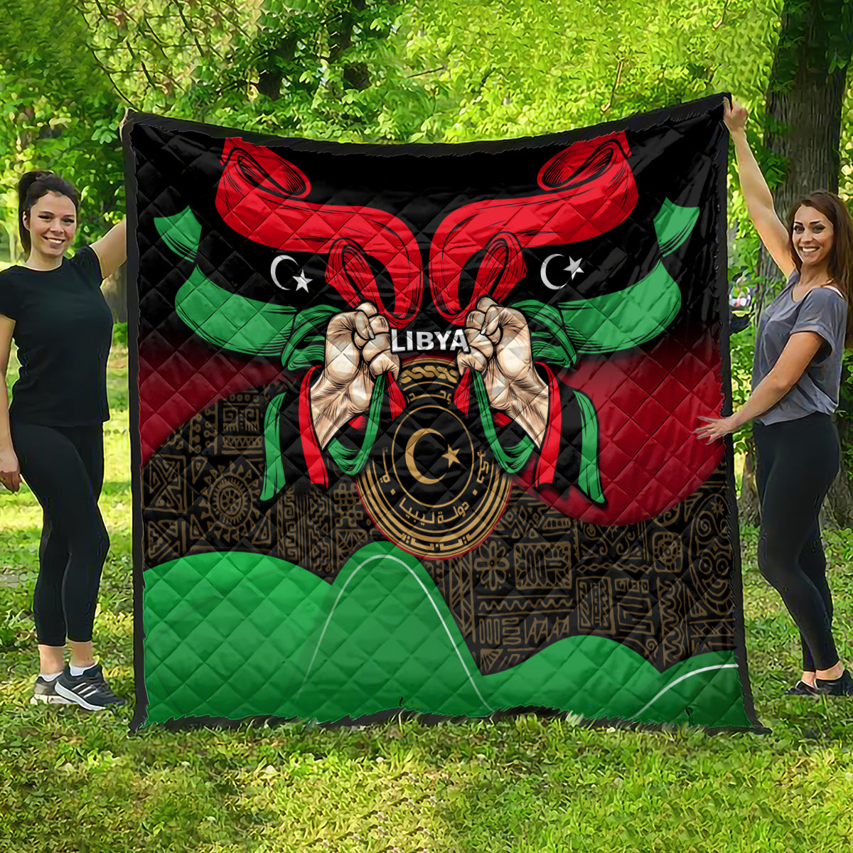 Libya flag-style quilt laid flat outdoors with bold red, black, and green emblem center.