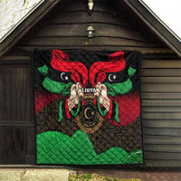 Libya flag-style quilt hanging outdoors with red, black, green eagle-like design.