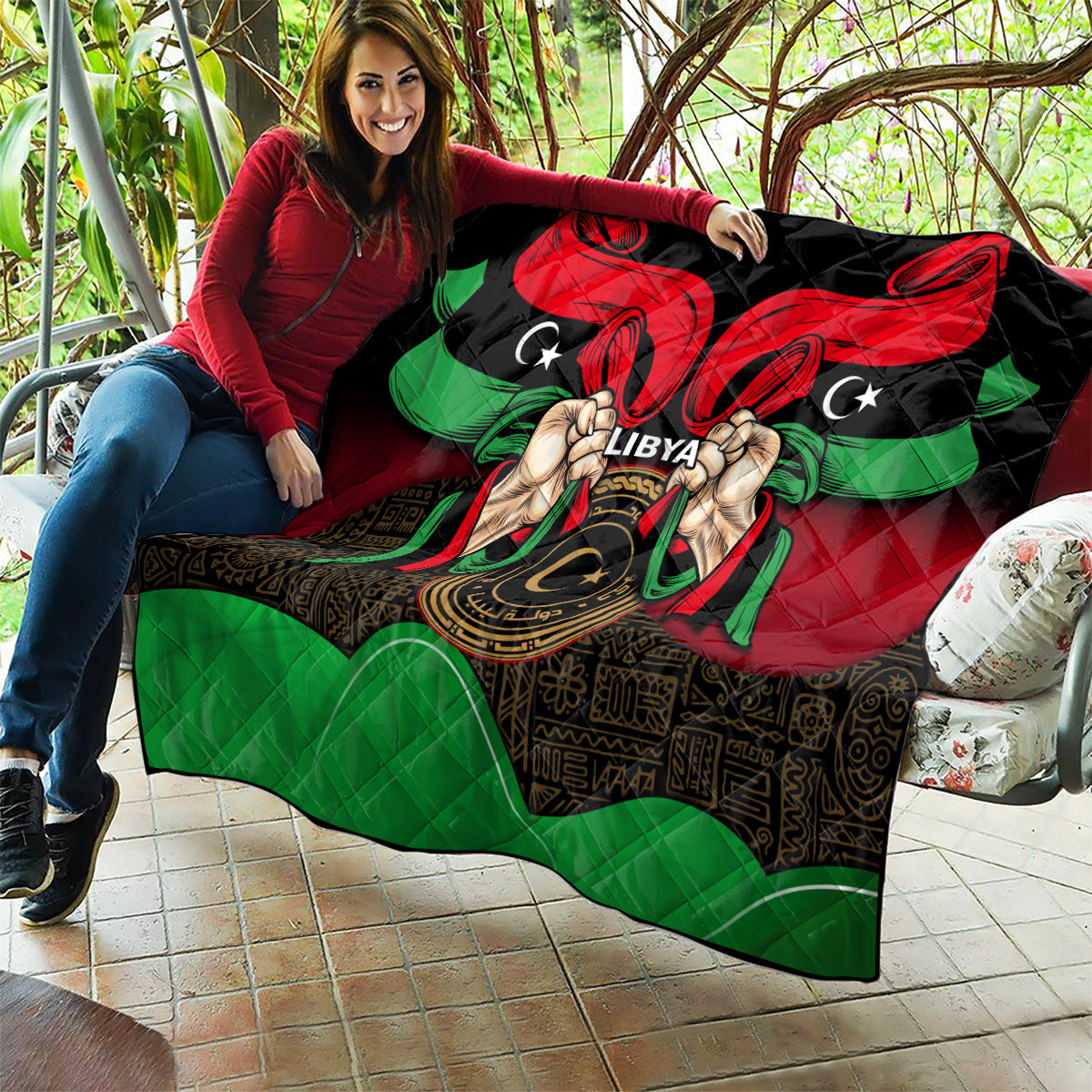 Libya flag-style quilt draped on sofa with red and black top and green lower section.