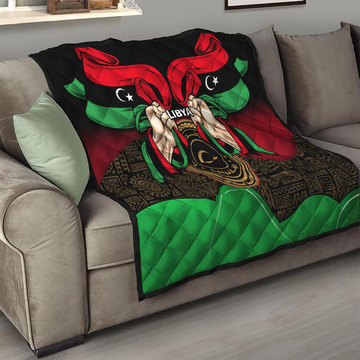 Libya flag-style quilt on couch with red wing shapes, green accents, and hands emblem.