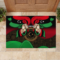 Black rubber doormat close-up with Libya emblem, hands, and red-green waving flag