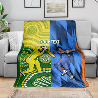Custom cricket blanket draped on a sofa, yellow and blue panels with orange edging and player art