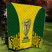 Australia cricket quilt on grass featuring central trophy, green-and-yellow chevron, and emblems