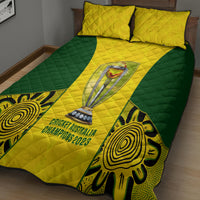 Yellow and green quilt with trophy emblem and two pillows on a bed, quilted texture