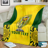 Yellow and green cricket blanket spread on a sofa, trophy logo and 'YOUR TEXT' print