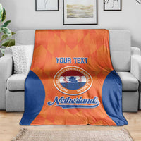 Orange and blue Netherlands custom baseball blanket draped on a gray sofa