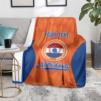 Orange and blue Netherlands custom blanket on a sofa with “Your Text” and emblem