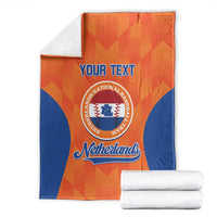 Orange and blue Netherlands custom blanket folded with “Your Text” and logo, plus white rolls