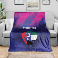 Blue and magenta cricket blanket on gray couch, centered 'YOUR TEXT' UAE falcon shield