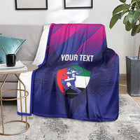 Cricket blanket draped over sofa: blue with magenta stripes, 'YOUR TEXT' and UAE shield
