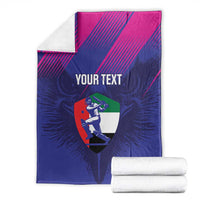 Blue and pink custom cricket blanket with 'YOUR TEXT' and UAE shield graphic, folded