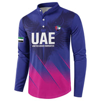 Blue henley sweatshirt with UAE crest, eagle-wing design, and pink diagonal stripe bottom