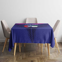 Blue tablecloth featuring crest graphic and “YOUR TEXT” on table with four chairs