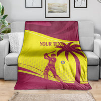 Custom cricket blanket in maroon and yellow with West Indies lion graphic, on gray sofa