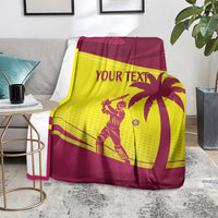 Custom cricket blanket in maroon and yellow West Indies design, folded over sofa arm