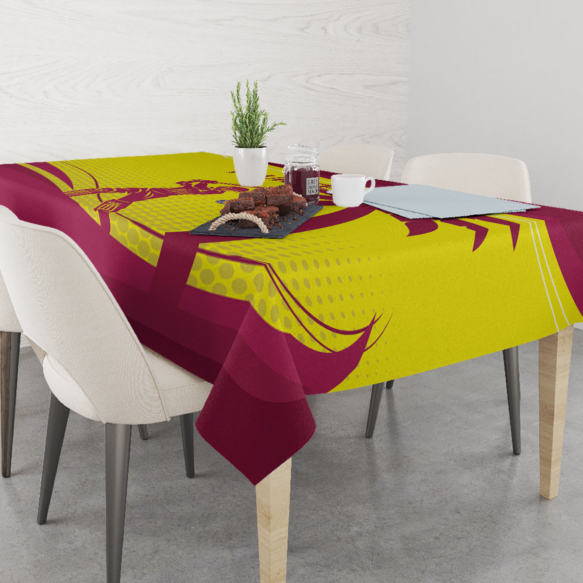 Custom cricket tablecloth with maroon base and yellow logo graphic on dining table