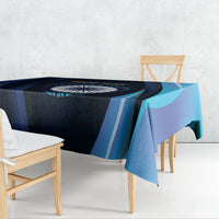 Blue cricket tablecloth with navy center panel and teal curved stripes on dining table.