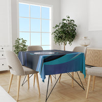 Blue cricket tablecloth with circular emblem and teal stripe accents on dining table.