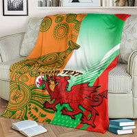 Rugby blanket over a couch arm in green, red, and orange with dragon mascot and crest.
