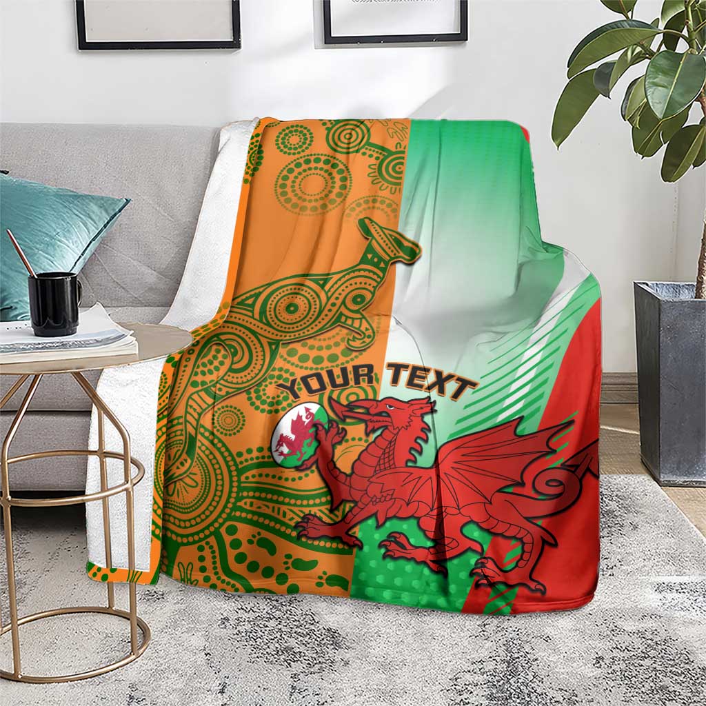 Rugby blanket folded on a floor beside a table, green, red, and orange with dragon mascot.