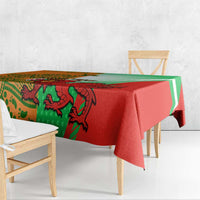 Red and green rugby tablecloth draped on a bench with large creature and stripe design