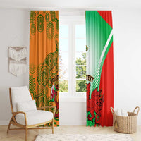 Rugby window curtains with orange patterned panel and green-red dragon panel by window