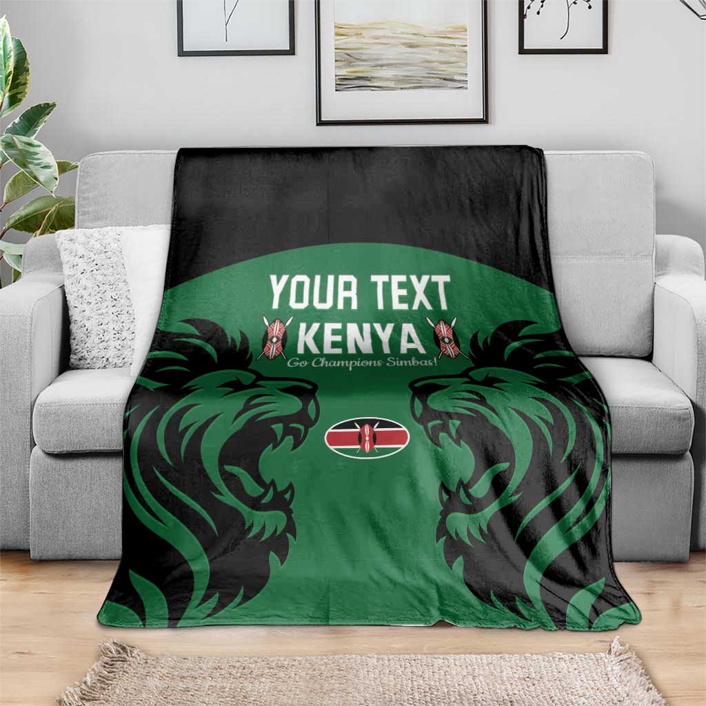 Green Kenya rugby blanket with black border and lion graphic, spread on gray couch